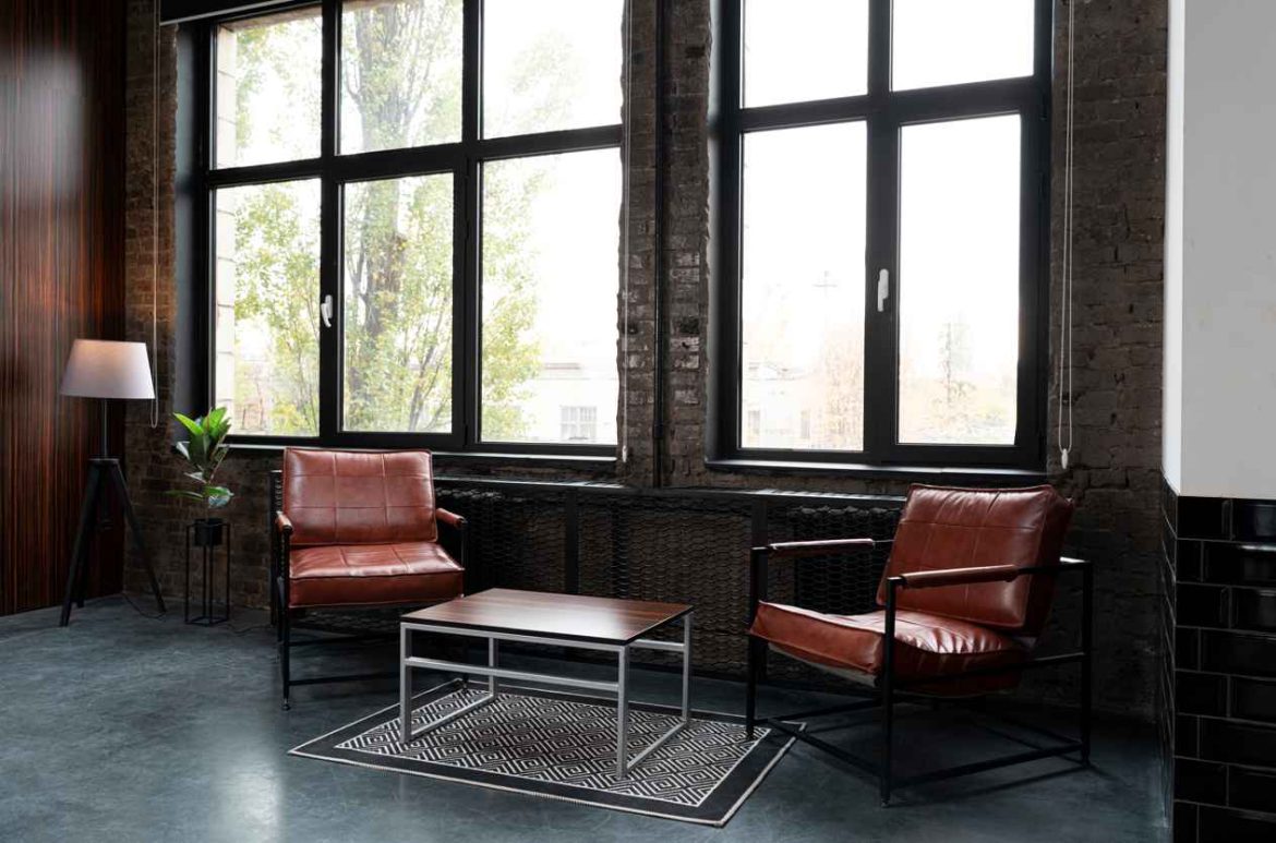 Salon moderne baigné de lumière doté de grandes ouvertures encadrées par une menuiserie pvc couleur bois gris anthrazit.