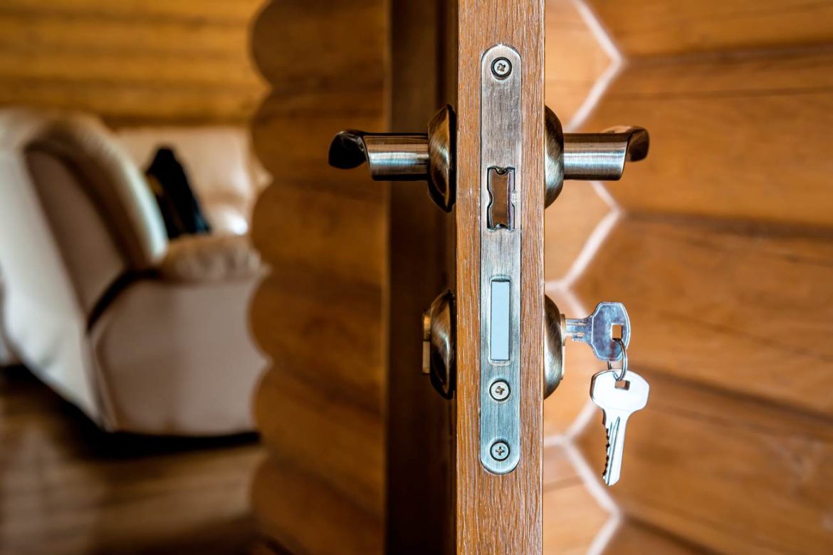 Une clé engagée dans la serrure d'une porte en bois ouverte, illustrant comment securiser porte d entree contre cambriolage serrurier paris.